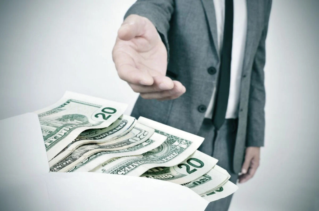 Man suit taking envelope full dollar tax rate on bonuses